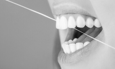 Dental floss. Taking care of teeth. Healthy teeth concept. Teeth Flossing. Smiling women use dental...