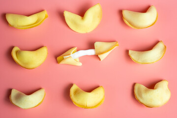 An open fortune cookie on a pink background. The concept of luck, lottery. Chinese New Year.