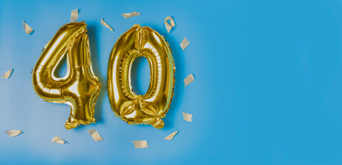 A balloon made of gold foil with the number forty. A birthday or anniversary card with the...