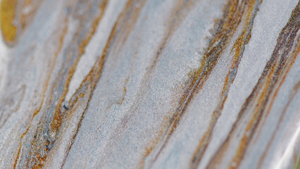 Glitter paint drip. Marble ink spill. Defocused metallic golden silver white green color sparkling texture fluid pouring flow motion bokeh light abstract art background.