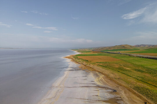 Aerial view of a road driving along the Tuz Golu (Lake Tuz), one of the largest hyper saline lake in the world, Central Anatolia Region, Turkey.