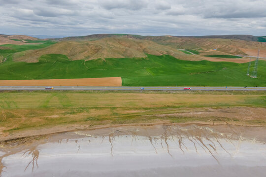 Aerial view of a road driving along the Tuz Golu (Lake Tuz), one of the largest hyper saline lake in the world, Central Anatolia Region, Turkey.