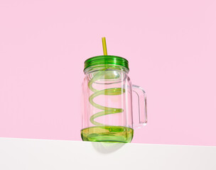 Original empty glass for various cocktails and drinks with green curved straw.