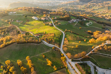 Aerial view of a mountains and hills landscape with vineyard and countryside houses at sunset in autumn colours, Irpinia, Avellino, Campania, Italy.
