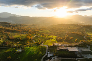 Aerial view of a mountains and hills landscape with vineyard and countryside houses at sunset in autumn colours, Irpinia, Avellino, Campania, Italy.