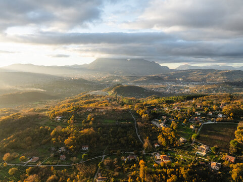 Aerial view of a mountains and hills landscape with vineyard and countryside houses at sunset in autumn colours, Irpinia, Avellino, Campania, Italy.