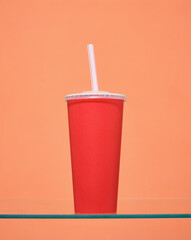A red cup with a straw and a tasty drink. Movie trip.