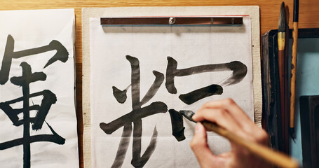 Man, calligraphy or hands of a Japanese artist in studio for art and script, letter with closeup...