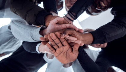bottom view. a group of diverse young people joining their hands together