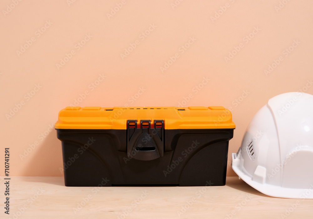 Wall mural black tool box with yellow cap and white helmet. building construction tools.