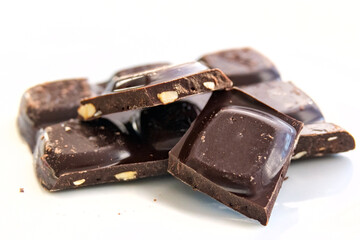 Broken bar of dark chocolate on a white background in close-up