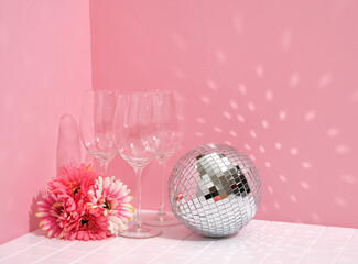 Luxury alcohol vacation. Disco ball and glasses for alcoholic beverages. Beautiful spring flowers.