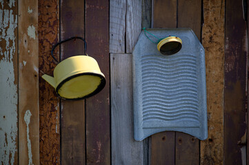 Old vintage enamel kettle and washboard on wooden wall, for backgrounds or textures