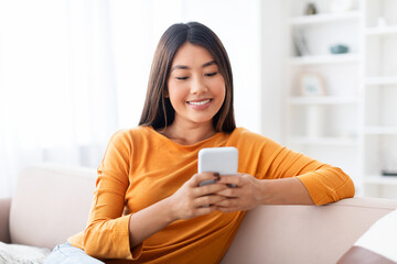 Closeup candid photo of young pretty asian lady using smartphone