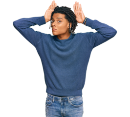 Young african american man wearing casual winter sweater doing bunny ears gesture with hands palms looking cynical and skeptical. easter rabbit concept.
