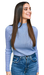 Young beautiful woman wearing casual winter sweater looking away to side with smile on face, natural expression. laughing confident.