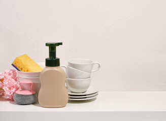 Set of clean tableware. Dish detergent and sponges. Copy space for text.