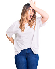 Young caucasian woman wearing casual clothes surprised with hand on head for mistake, remember error. forgot, bad memory concept.