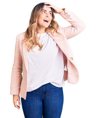 Young caucasian woman wearing business clothes smiling confident touching hair with hand up gesture, posing attractive and fashionable