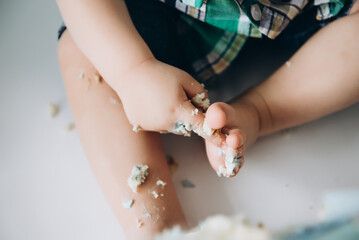 Cute photo of a child with a cake. Birthday. White backgraund.Children's hands and feet.