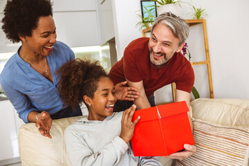 Parent make birthday surprise to excited  daughter, happy little girl child amazed by gift box present by mom and dad