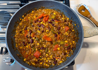 Overhead view of homemade cooked chili food on top of natural gas stove