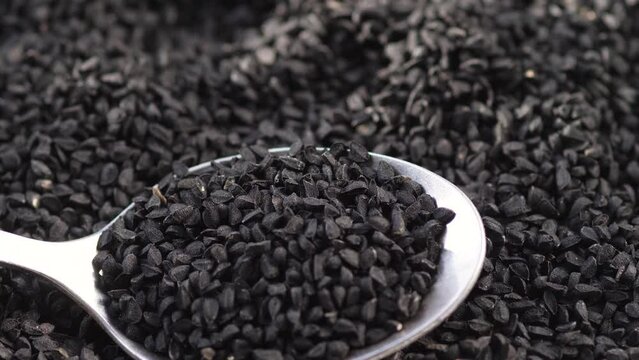 black cumin seeds heap rotation. macro black cumin. cooking with black cumin seeds