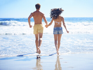 Couple, holding hands and running on beach for holiday, swimming in summer and vacation by ocean....