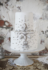 Fototapeta na wymiar White wedding cake with silver decoration
