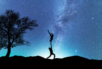 Man and woman silhouettes dancing in the night, on the bright Milky Way Galaxy background.