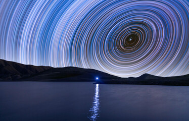 Beautiful night landscape,  star trailers  on the lake. Time-lapse, long exposure.