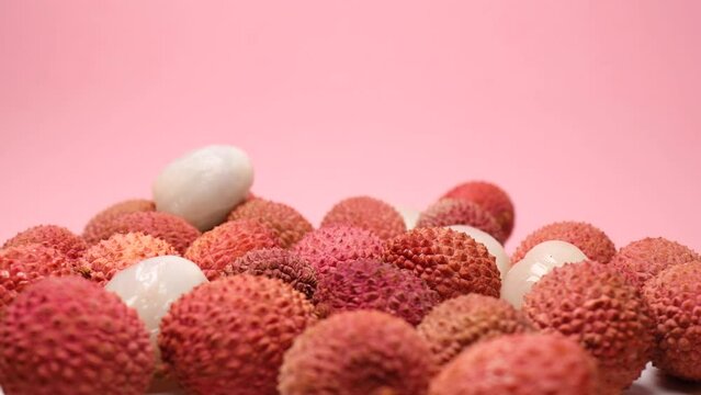 Lychee fruits, rotation in circle. tropical fruit lychee, Turning. selective focus. Lychee fruits on a pink background