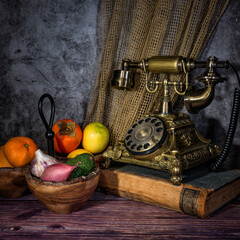 ein altes Telefon mit Früchten und alten Büchern