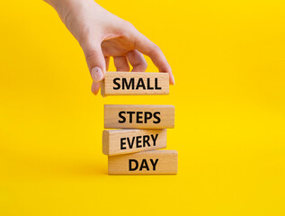 Small Steps Every Day symbol. Wooden blocks with words Small Steps Every Day. Beautiful yellow background. Businessman hand. Business and Small Steps Every Day concept. Copy space.