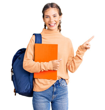 Beautiful caucasian woman with blonde hair wearing student backpack and holding book smiling happy pointing with hand and finger to the side