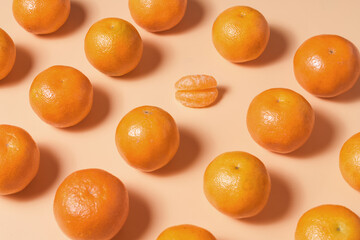 A creative pattern of bright tangerines on a soft background with two lip-shaped mandarin slices in...