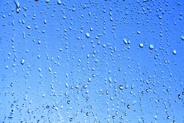 Realistic water droplets on blue background. Raindrops on the window. Blue water drop on glass