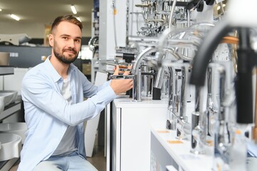 Fototapeta premium A large selection of water faucets. Man chooses a products in a sanitary ware store