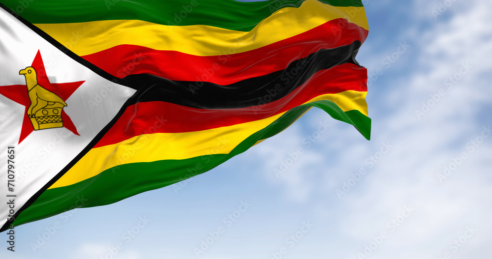 Wall mural Close-up view of the Zimbabwe national flag waving in the wind