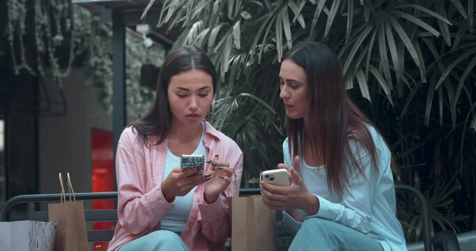 Women friends on bench communicating using phones reflecting sincere friendship. Sincere women friendship their interaction genuine smiles Sincere friendship symbol camaraderie elegance happiness.