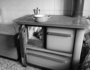 old wood stove of a cheap kitchen with moka to making coffee in white and black