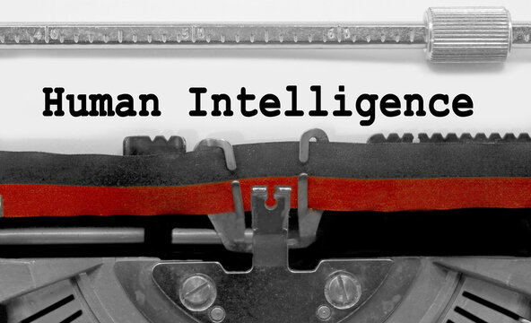 Big text human Intelligence by the old typewriter on white paper sheet