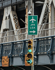 JFK and LGA sign on traffic light with manhattan bridge in the background (close up of directional...