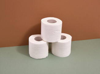 Rolls of toilet paper stand in a pyramid shape on the table. Hygiene and domestic life.