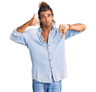 Young hispanic man wearing summer style doing thumbs up and down, disagreement and agreement expression. crazy conflict
