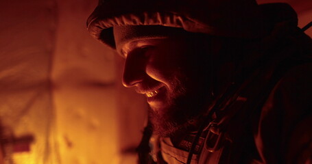 Portrait of a Ukrainian chaplain in a dugout. Close-up of vee in the dark dugout.