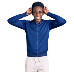 Fototapeta premium Young african american man wearing sportswear posing funny and crazy with fingers on head as bunny ears, smiling cheerful