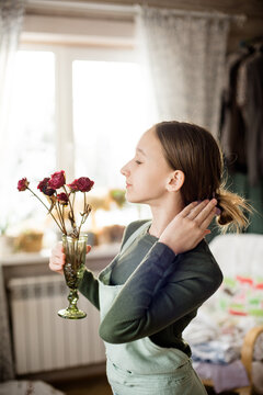 A housewife girl holds a beautiful bouquet of peonies in her hands. Vertical photo. tinted photo.