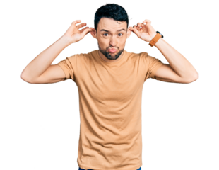 Hispanic man with beard wearing casual t shirt smiling pulling ears with fingers, funny gesture. audition problem