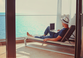 Relaxed young man at home on the balcony. Holiday and travel concept